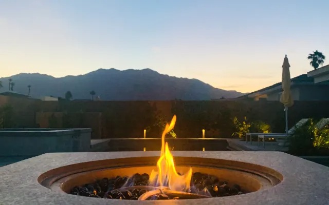 Fire pit burning at dusk with the mountains behind