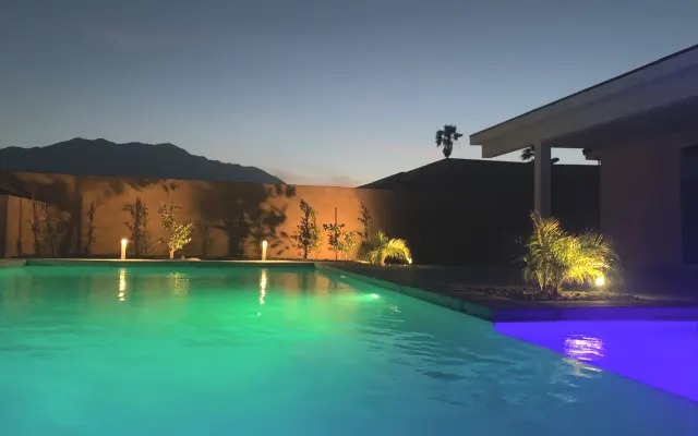The pool lit teal and violet after dark