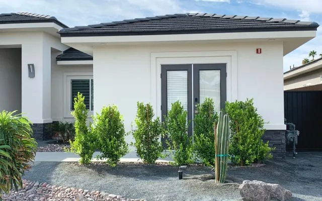 The exterior of the home with desert landscaping and a cactus