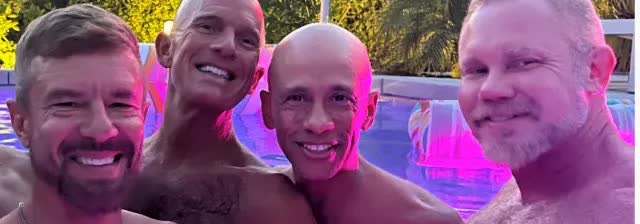 Friends together in the pool under coloured lights at night